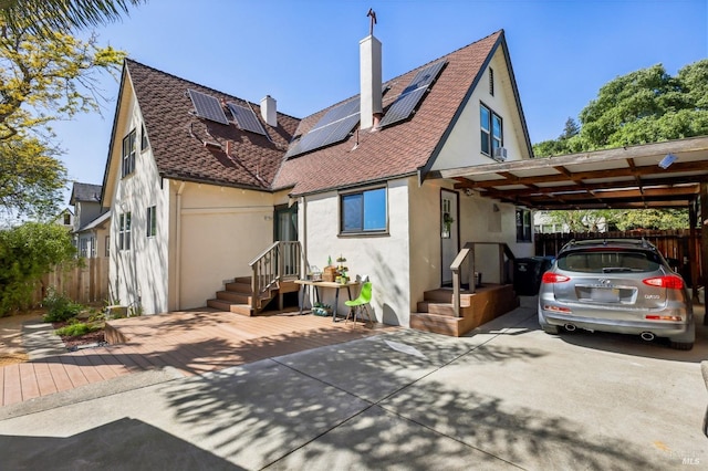 17 Hanns Ave, Vallejo, CA 94590 - rear view of house with a chimney, fence, solar panels, stucco siding, and a carport