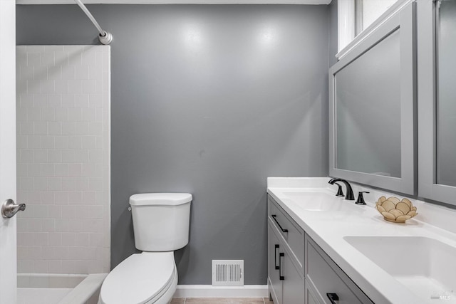 bathroom featuring toilet, a sink, a shower, and double vanity