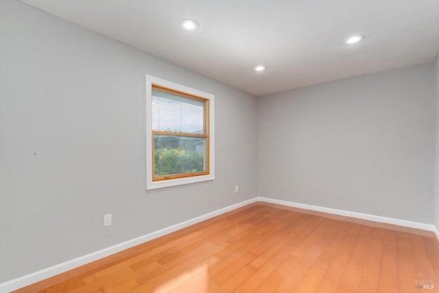 unfurnished room with light wood-style flooring, baseboards, and recessed lighting