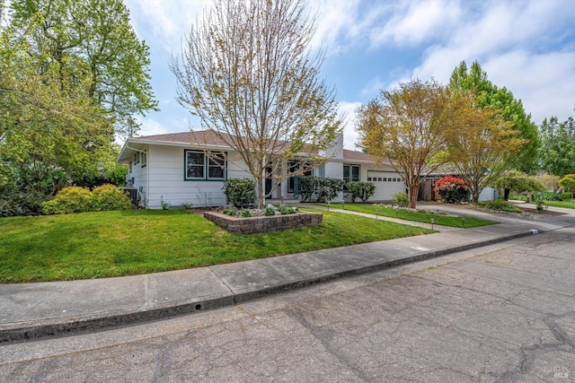 ranch-style home with an attached garage, a front lawn, and concrete driveway