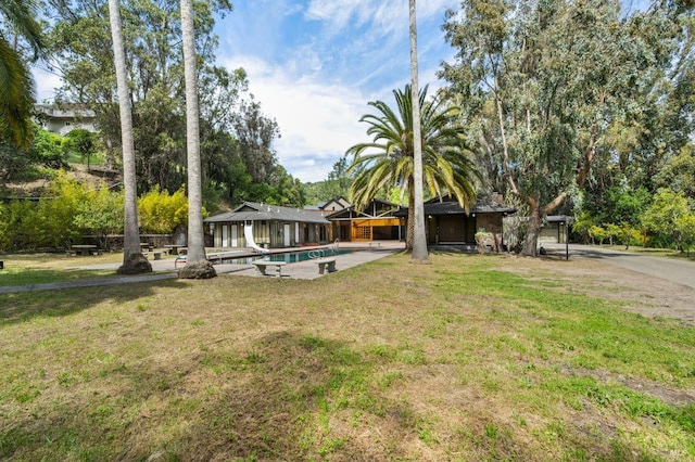 exterior space with an outdoor pool and a yard