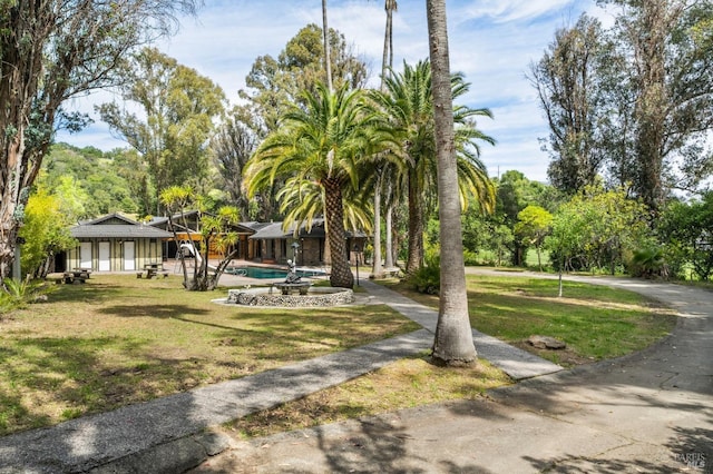 view of community with a lawn and a swimming pool