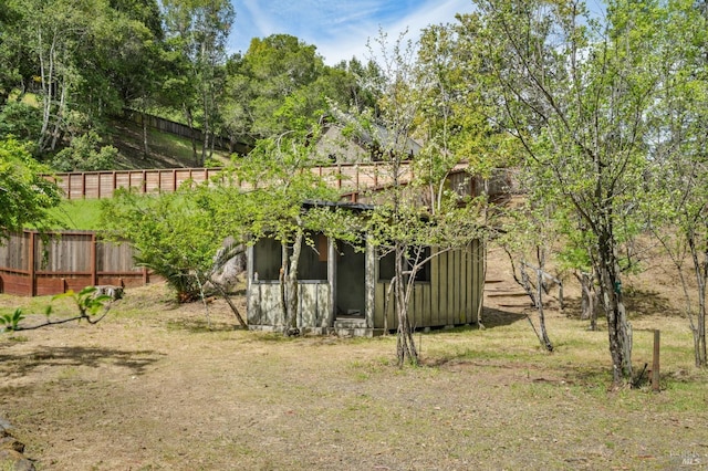 view of yard featuring fence and an outbuilding