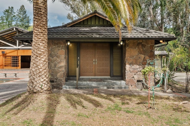 view of front facade with a tile roof and stone siding