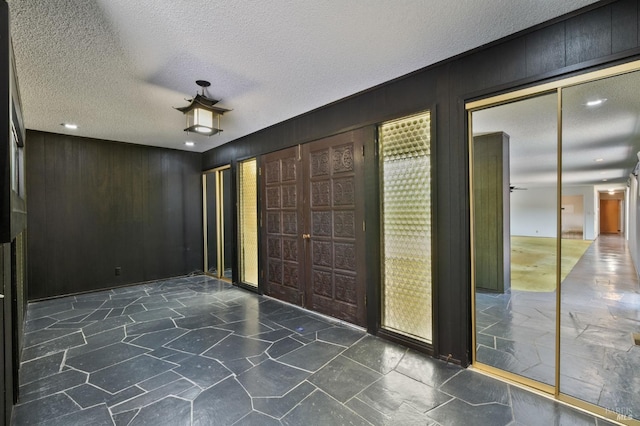 entrance foyer featuring a textured ceiling and stone flooring