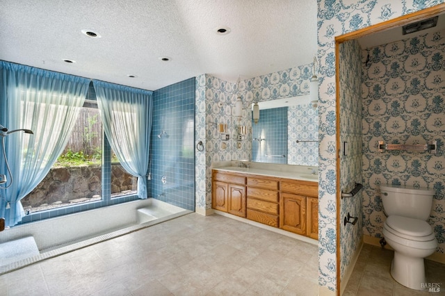 full bathroom with wallpapered walls, double vanity, toilet, a sink, and a textured ceiling