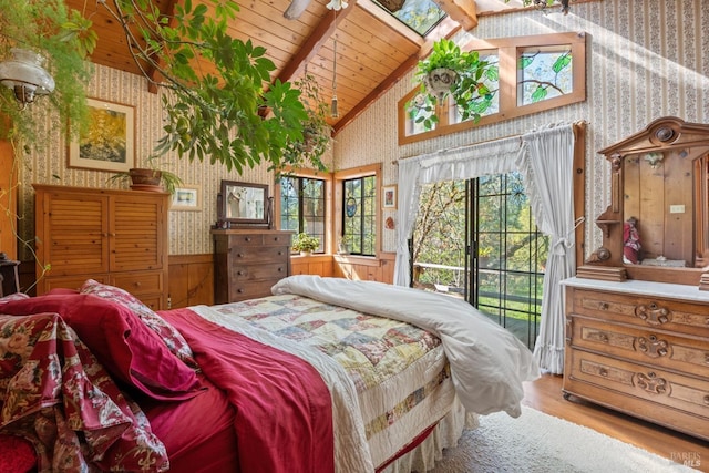 bedroom with vaulted ceiling with skylight, wood finished floors, wallpapered walls, wooden ceiling, and access to exterior