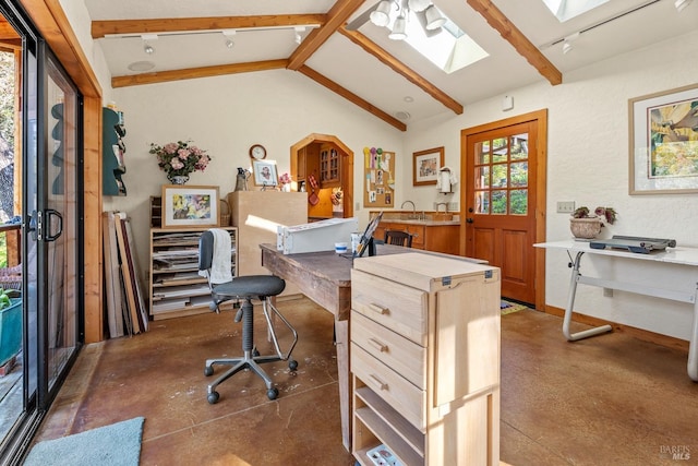 home office featuring vaulted ceiling with skylight, finished concrete flooring, and a sink