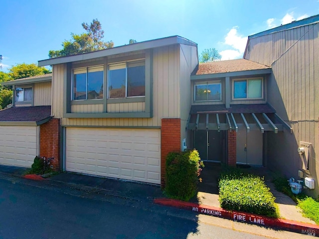 view of front of house featuring brick siding, a garage, and aphalt driveway
