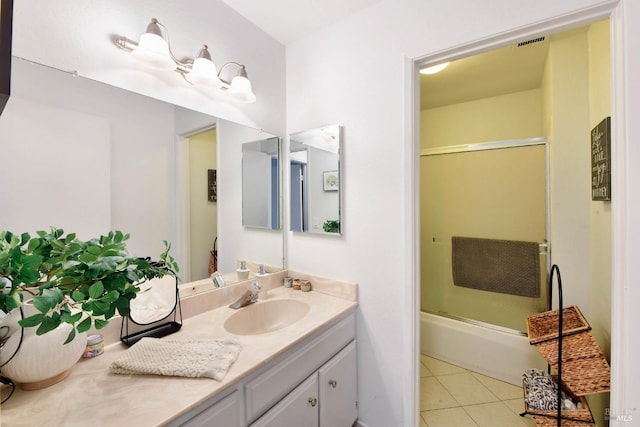 bathroom with visible vents, combined bath / shower with glass door, vanity, and tile patterned flooring