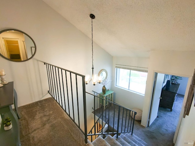 stairs with vaulted ceiling, carpet floors, a notable chandelier, and a textured ceiling