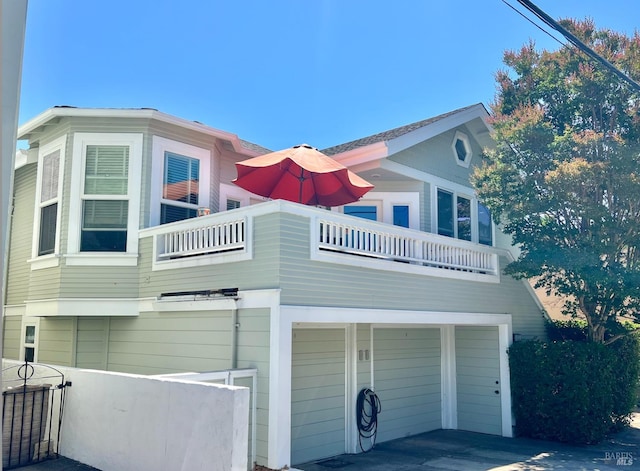 exterior space featuring an attached garage and a balcony