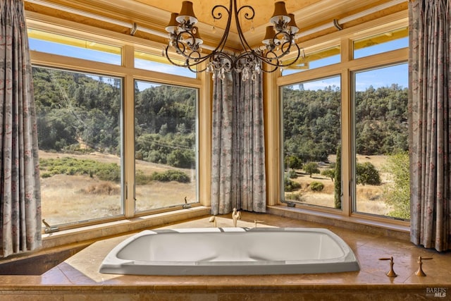 bathroom featuring a wealth of natural light, a notable chandelier, and ornamental molding