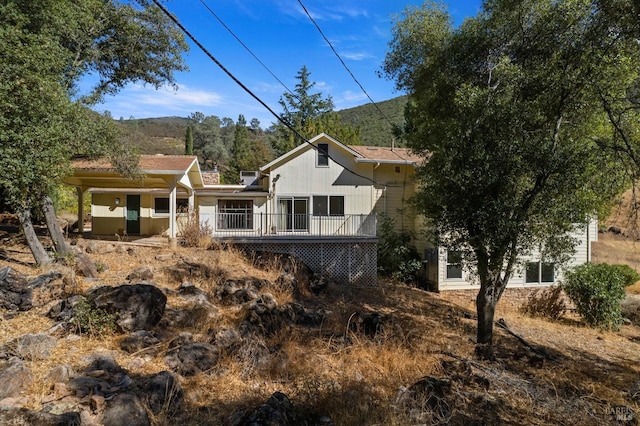 rear view of property featuring a deck