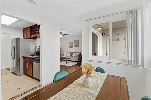 dining room with baseboards, a ceiling fan, and visible vents