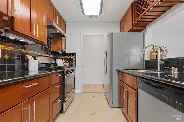 kitchen with brown cabinetry, visible vents, appliances with stainless steel finishes, a sink, and under cabinet range hood