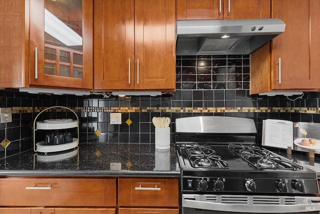 kitchen featuring range with gas stovetop, backsplash, under cabinet range hood, and brown cabinets