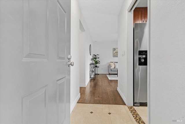 hall with baseboards and light tile patterned flooring