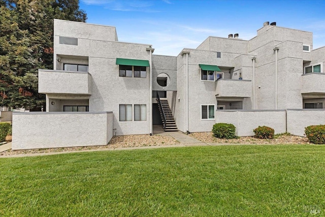 view of building exterior with fence and stairway