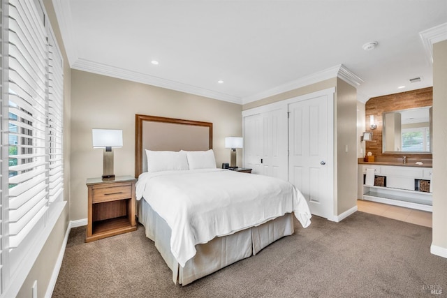 bedroom featuring a sink, baseboards, carpet, recessed lighting, and multiple closets