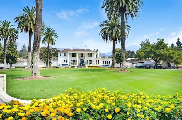surrounding community with a lawn and a mountain view