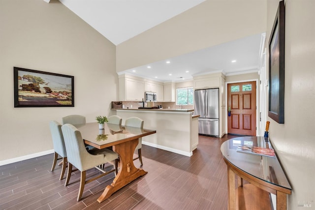 dining area with high vaulted ceiling, dark wood finished floors, baseboards, and ornamental molding