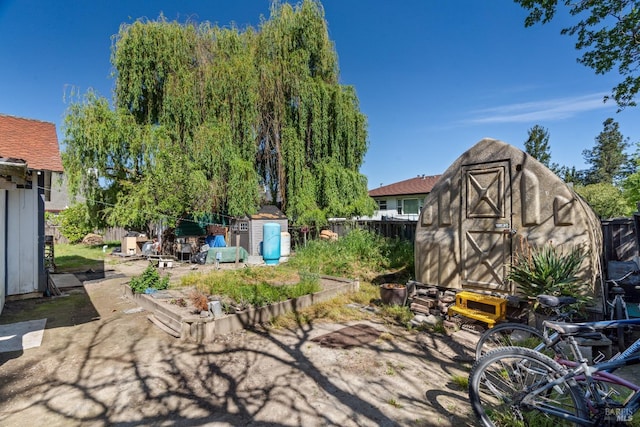 view of patio with an outbuilding, a storage shed, and fence