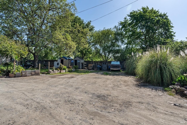 view of yard featuring an outbuilding and fence