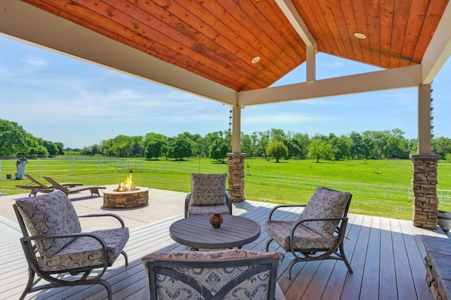 wooden terrace with fence, a lawn, an outdoor fire pit, and a patio area