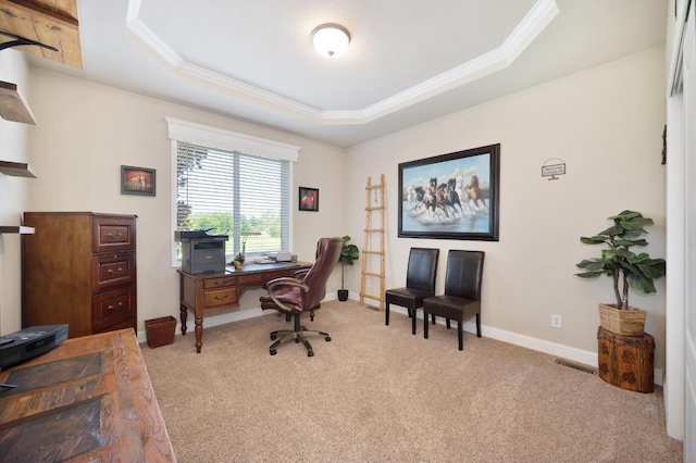 office area featuring carpet flooring, a tray ceiling, visible vents, baseboards, and ornamental molding