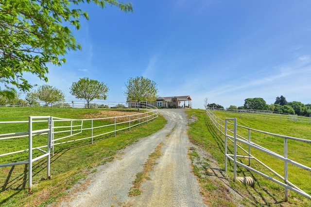 view of street with a rural view and driveway
