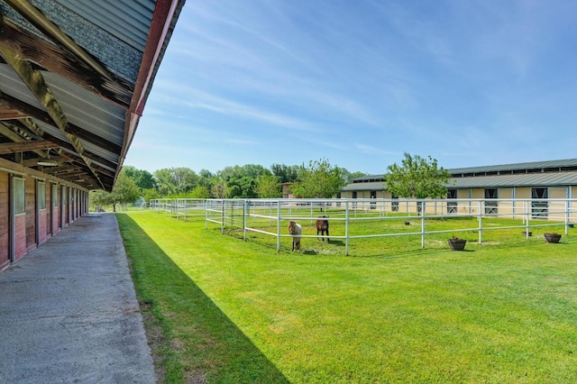 view of yard featuring a rural view, an outbuilding, and an exterior structure