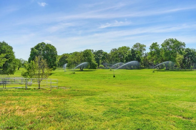 view of yard with fence and a rural view
