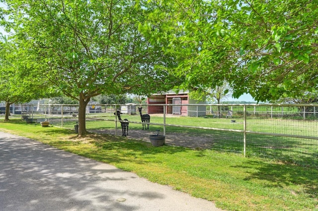 view of community with a lawn and fence