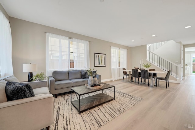 living area with stairway, baseboards, recessed lighting, and light wood-style flooring