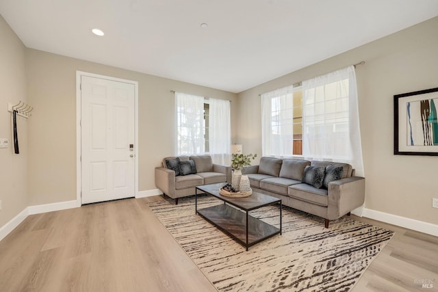 living area with recessed lighting, baseboards, and light wood-type flooring
