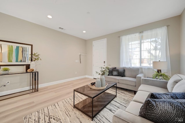 living area with recessed lighting, baseboards, visible vents, and light wood-style flooring