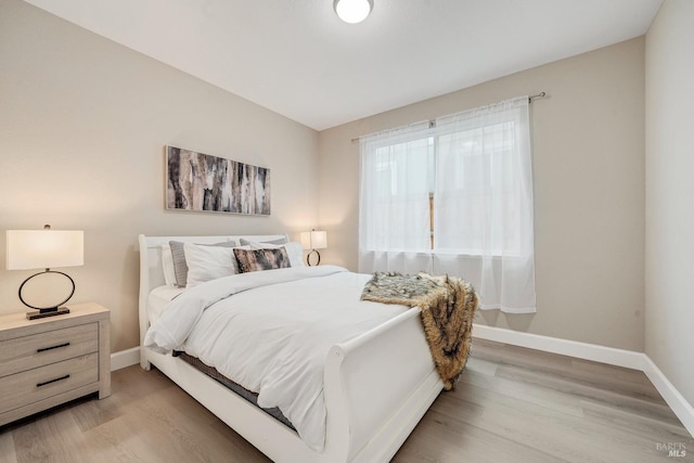 bedroom with baseboards and light wood-style flooring