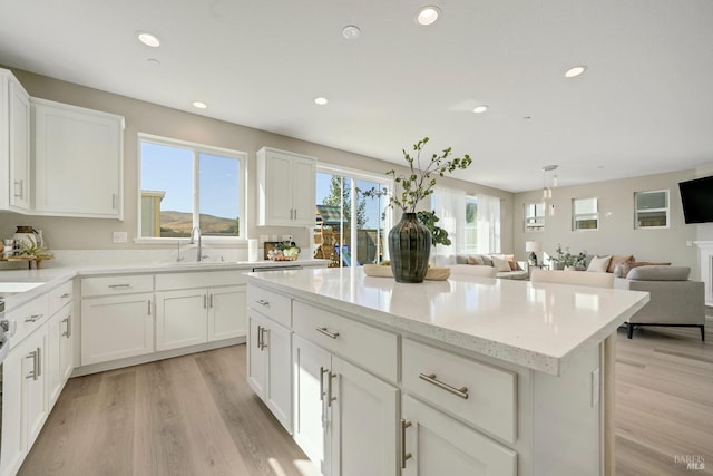 kitchen with recessed lighting, open floor plan, a sink, and a kitchen island