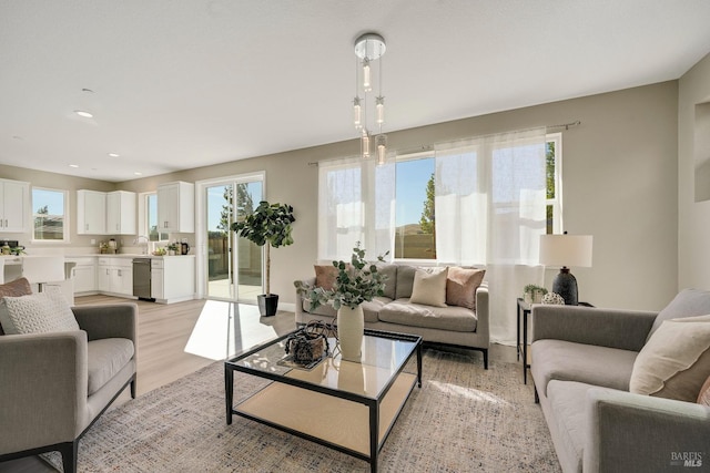 living room with light wood-type flooring and recessed lighting