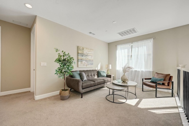 carpeted living area featuring baseboards and visible vents