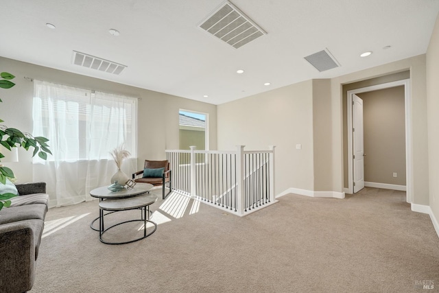 sitting room with light carpet, visible vents, and baseboards