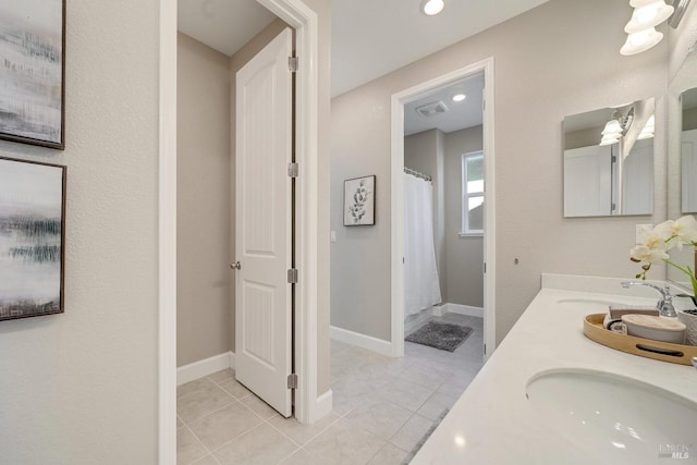 bathroom with tile patterned flooring, a sink, recessed lighting, and double vanity