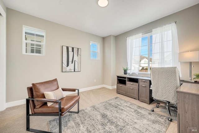 office space with light colored carpet, baseboards, and a healthy amount of sunlight