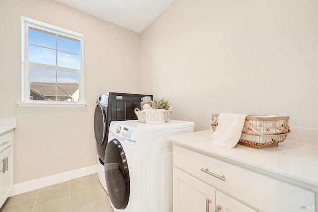 laundry area with cabinet space, baseboards, washer and dryer, and light tile patterned flooring