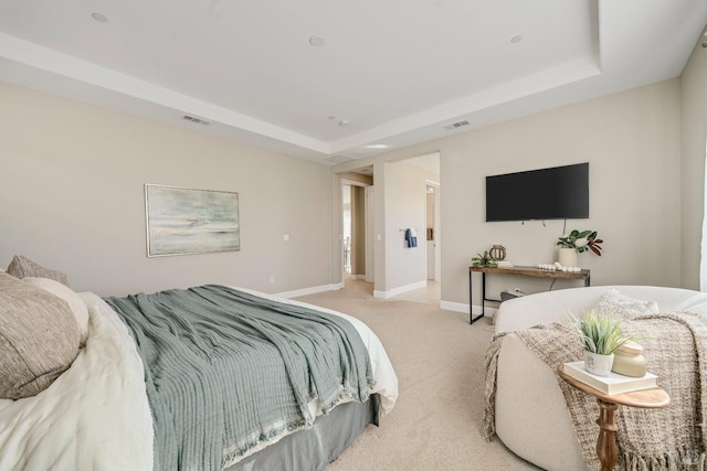 bedroom featuring light carpet, a tray ceiling, visible vents, and baseboards
