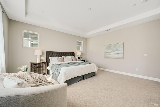bedroom featuring visible vents, baseboards, and a tray ceiling