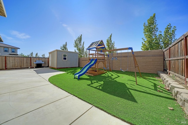 view of yard featuring a patio area, a fenced backyard, an outdoor structure, and a playground