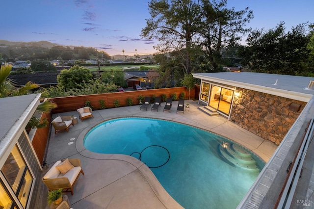 view of swimming pool featuring a fenced backyard, a fenced in pool, and a patio area