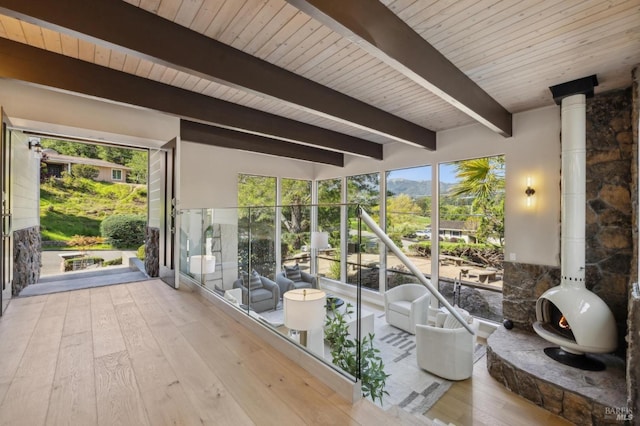 sunroom / solarium featuring beam ceiling and a mountain view